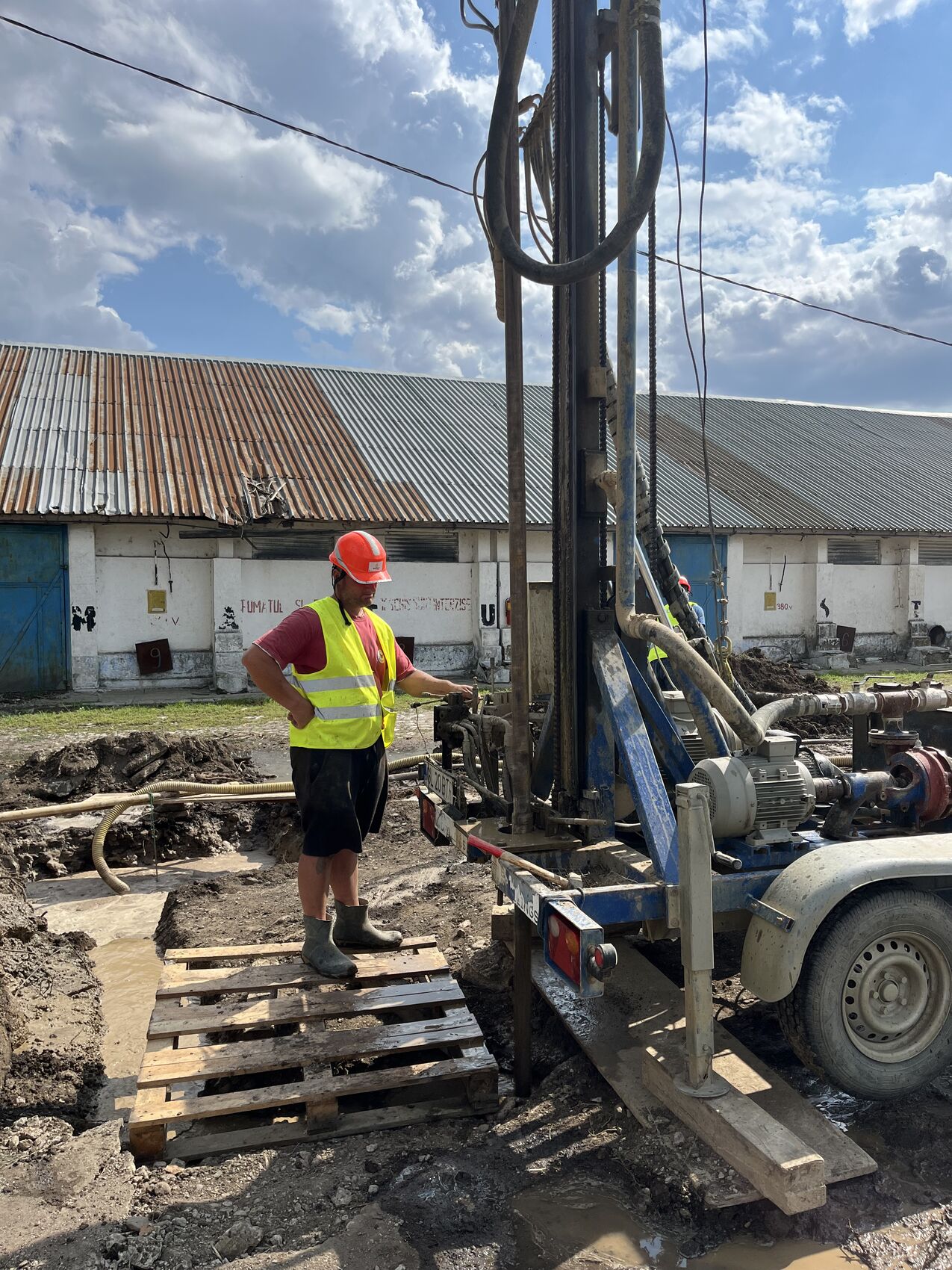 Operator Butura Drillings lângă utilajul de foraj, pe o lucrare industrială